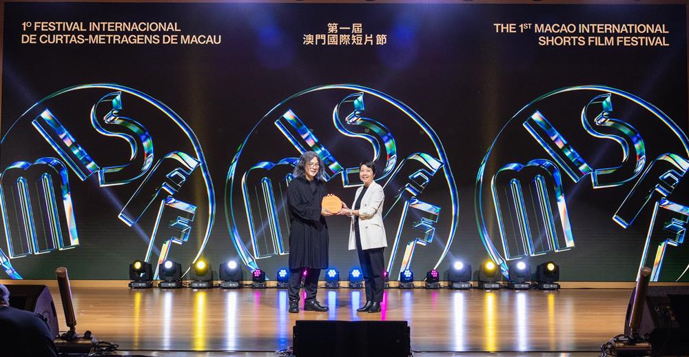 President of the Cultural Affairs Bureau, Leong Wai Man, presents a souvenir to "Director in Focus" Shunji Iwai